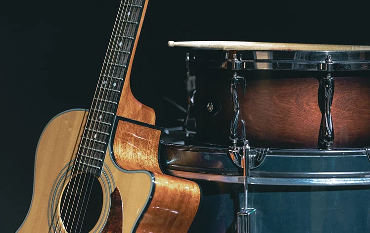 foto de um violão e caixa de bateria