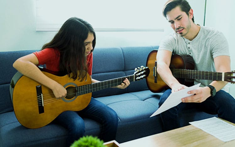 Aluna aprendendo violão com o professor