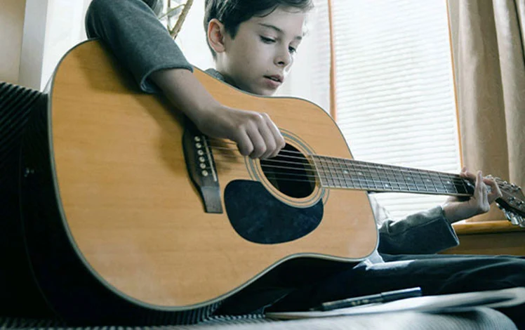 criança tocando violão