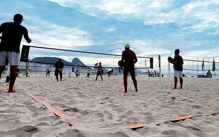 pessoas jogando beach tennis na praia