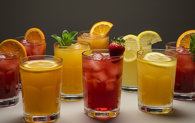 Copo de drink sem álcool colorido decorado com frutas frescas em mesa elegante, perfeito para celebrações e momentos especiais.