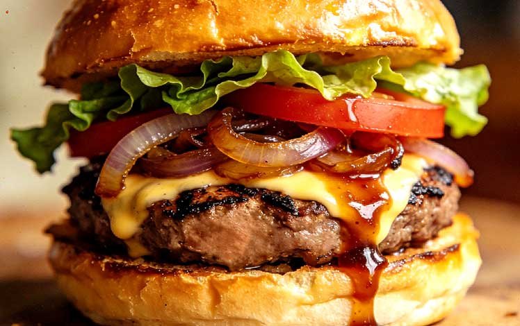 Hambúrguer artesanal com molho especial escorrendo durante a montagem