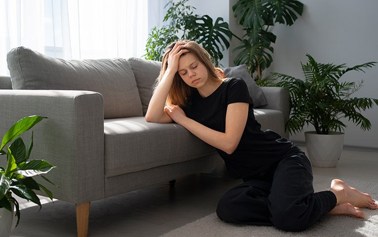 Mulher em momento de pausa refletindo sobre a rotina, representando cansaço e autoexigência