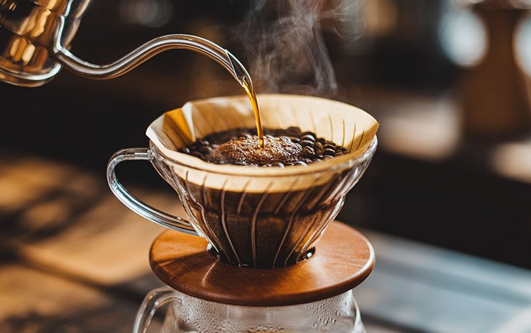 Barista preparando café especial em método filtrado com grãos de alta qualidade e aroma intenso.