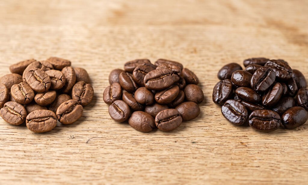 Grãos de café com torras clara, média e escura para comparação.